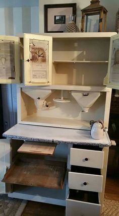 an old desk has been painted white and is being used as a hutch for storage