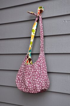 a handbag hanging on the side of a gray house with a colorful floral print