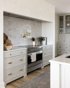 A light and bright kitchen, neutral kitchen cabinets with beautifully staged kitchen decor. Light grey cabinets. Large textured range hood. Kitchen Reno, Counter Tops, Kitchen Tiles, Beautiful Kitchens, Tile Backsplash, Kitchen Backsplash