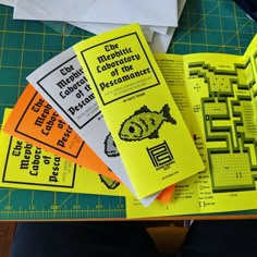 four books are sitting on top of a cutting board with scissors and paper next to them