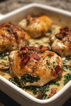 chicken with spinach and cheese in a white casserole dish