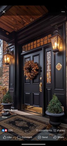 a black front door with two lights and a wreath on the side entrance to a house