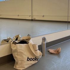 a pair of ballet shoes and a tote bag sitting on the floor