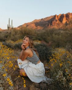 a woman is sitting on a rock in the desert