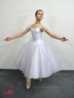 a young ballerina in a white tulle dress with her arms stretched out and hands outstretched