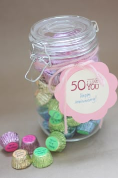 a jar filled with lots of colorful candies next to a tag that says 50 you