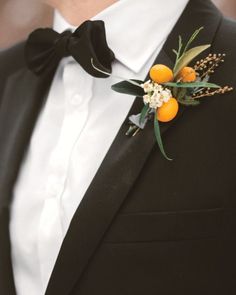 a man in a tuxedo with an orange boutonniere on his lapel