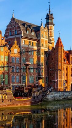 an old ship is docked in front of some buildings