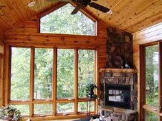 a living room filled with furniture and a fire place in front of a large window