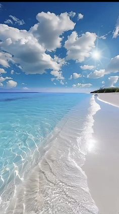 the beach is clear and blue with white clouds in the sky above it, as well as water below