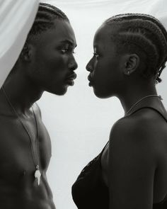 two black women are facing each other in front of a white background and one is wearing a necklace