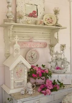 there is a white shelf with pink flowers on it and other things in the room