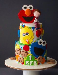 a three tiered cake decorated with sesame street characters