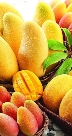 there are many different fruits in baskets on the table, including mangos and peaches