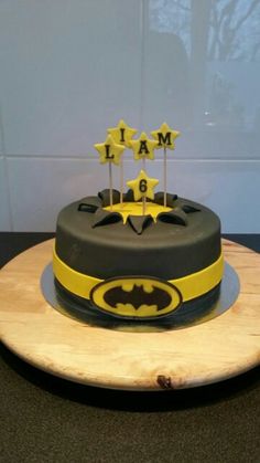 a batman themed birthday cake on a wooden platter