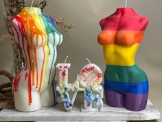 there are three candles that have been made to look like the letters love and rainbow