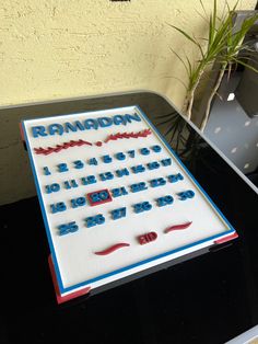 a birthday cake that is on top of a table with a plant in the background