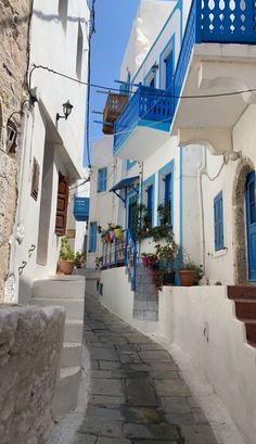 an alley way with blue balconies and white buildings