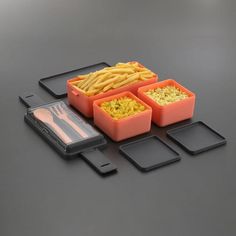 three plastic containers filled with food sitting on top of a black table next to two cell phones