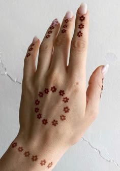 a woman's hand with small crosses on it