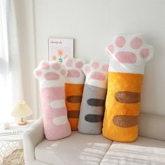 three stuffed animals sitting on top of a couch in front of a white wall and window