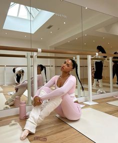 a woman sitting on the ground in front of mirrors