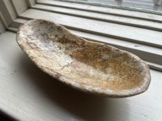 a dirty bowl sitting on top of a window sill