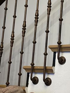 a cat sitting on top of a wooden banister next to a stair case in a house