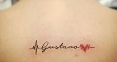 the back of a woman's shoulder with a heartbeat tattoo that reads gustano