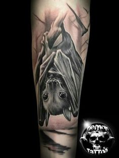 a black and grey tattoo with a bat on it