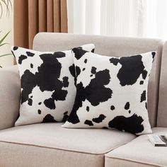 two black and white pillows sitting on top of a couch