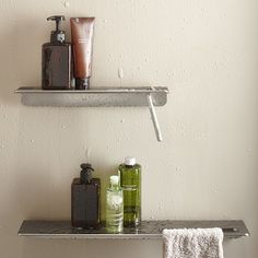 two shelves with towels, soaps and other items on them against a wall in a bathroom