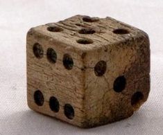 a close up of a wooden dice on a white surface