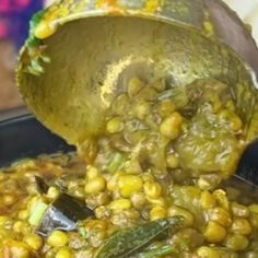 someone is pouring some food into a large pot filled with it's leaves and vegetables