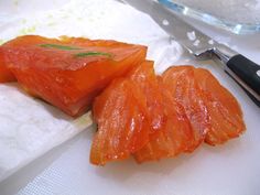 two pieces of raw salmon sitting on top of a cutting board next to a knife