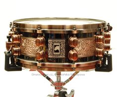 a close up of a metal drum on a white background with an intricate design in the middle