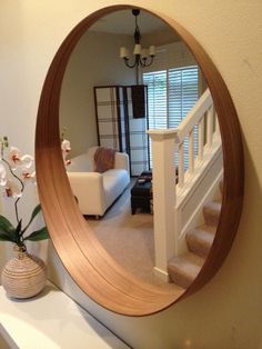 there is a mirror on the wall in this living room that has stairs leading up to it