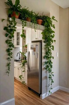 a refrigerator covered in plants next to a kitchen