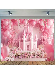 a pink castle backdrop with balloons and flowers