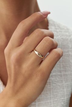 a woman's hand with a gold ring on her finger