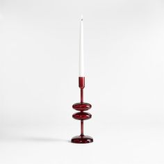 a red candle holder sitting on top of a white table