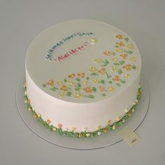 a birthday cake decorated with flowers and leaves