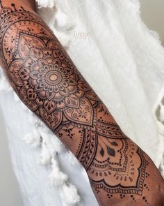 a person with a tattoo on their arm that has an intricate design in the middle