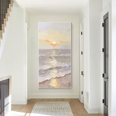 a painting is hanging on the wall next to a stair case in a white room