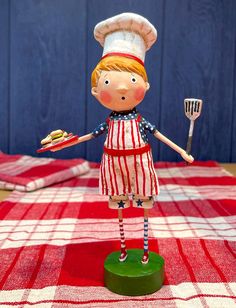 a small toy is standing on a red and white checkered tablecloth with a fork in it's hand