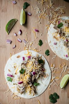 two tortillas topped with shredded cheese, onions and cilantro