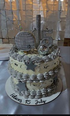 a birthday cake that is decorated with stars and silver decorations on the top, sitting on a table