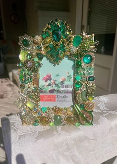 a green and gold photo frame sitting on top of a table