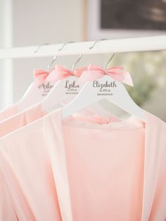 three pink dresses hanging on a white hanger