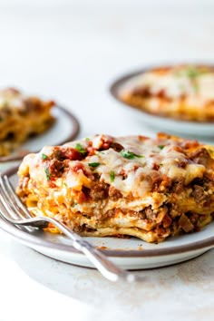 lasagna casserole on a plate with a fork and another dish in the background